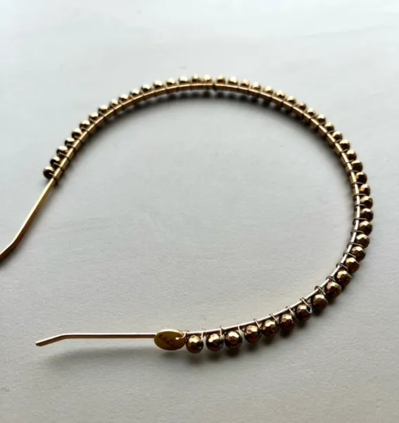 Delikatna złota błyszcząca opaska do włosów.