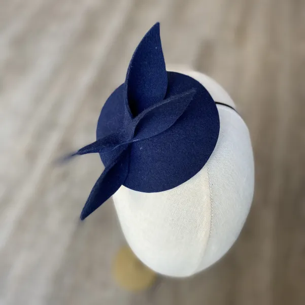 Granatowy mini kapelusik z gustowną ozdobą.