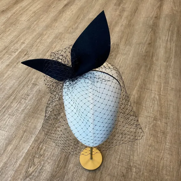 Gigantyczna czarna kokarda z woalką na głowę.