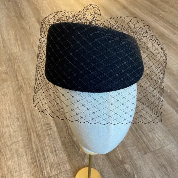 Asymetryczny elegancki czarny toczek z woalką na oczy.