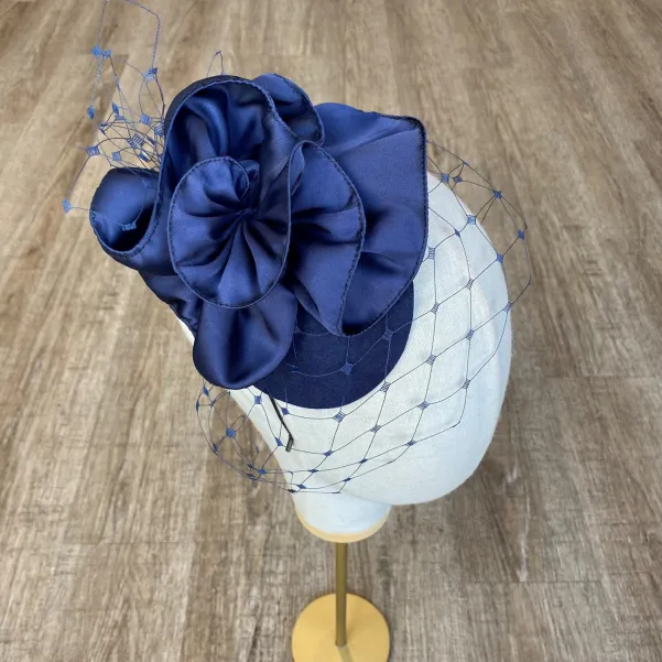 Granatowy mini toczek-fascynator z nieoczywistym kwiatem i woalką.