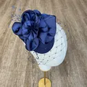 Granatowy mini toczek-fascynator z nieoczywistym kwiatem i woalką.
