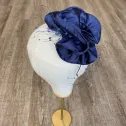 Granatowy mini toczek-fascynator z nieoczywistym kwiatem i woalką.