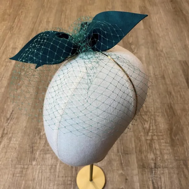 Zielony butelkowy fascynator z woalką.