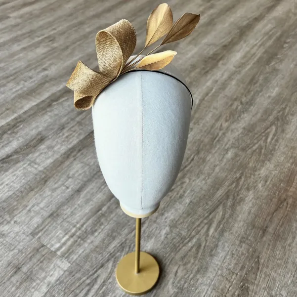 Delikatny fascynator na opasce w złotym kolorze.