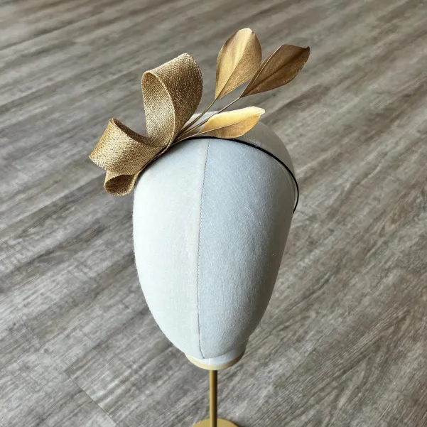 Delikatny fascynator na opasce w złotym kolorze.
