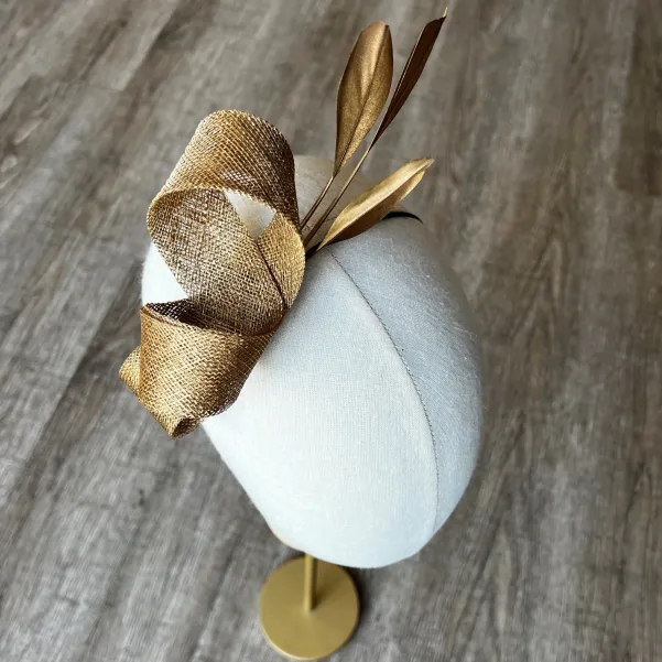 Delikatny fascynator na opasce w złotym kolorze.