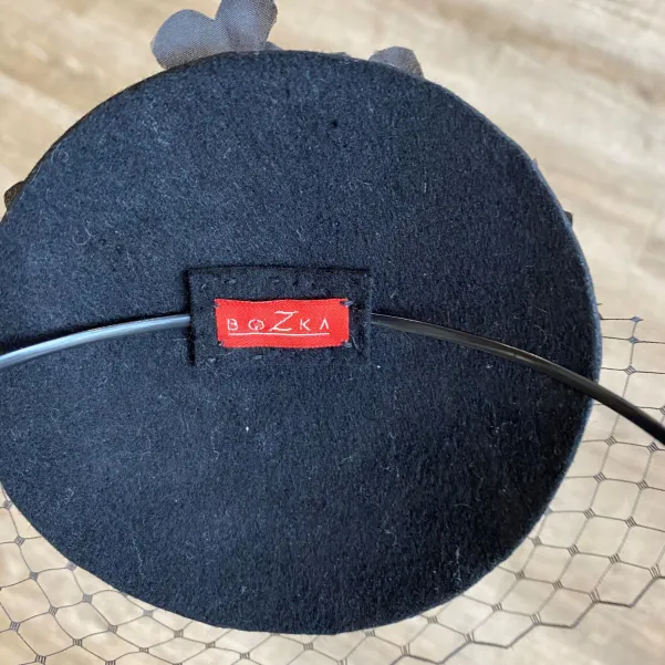 Czarny toczek zdobiony ręcznie formowanymi jedwabnymi kwiatami.