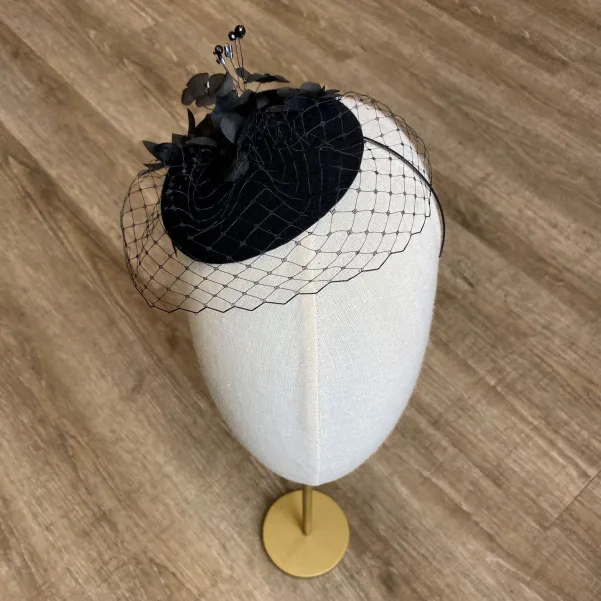 Czarny toczek zdobiony ręcznie formowanymi jedwabnymi kwiatami.