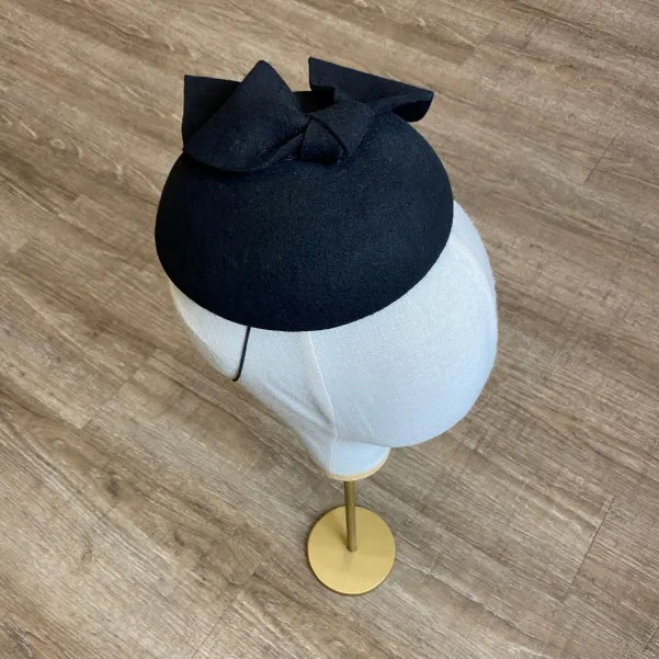 Czarne eleganckie nakrycie głowy kokardą.