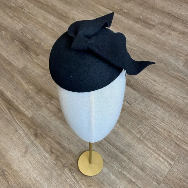 Czarne eleganckie nakrycie głowy kokardą.