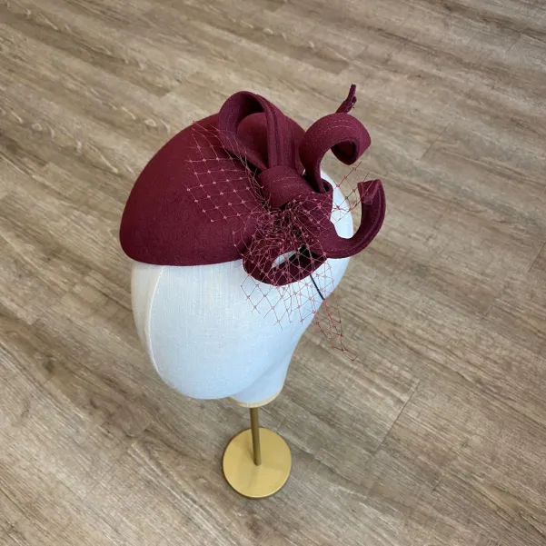 Ozdobne nakrycie głowy- mały burgundowy kapelusz.