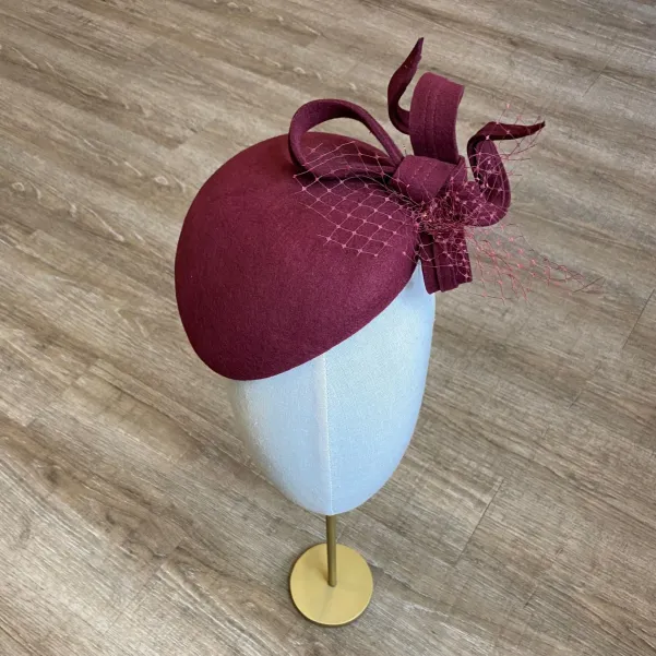 Ozdobne nakrycie głowy- mały burgundowy kapelusz.