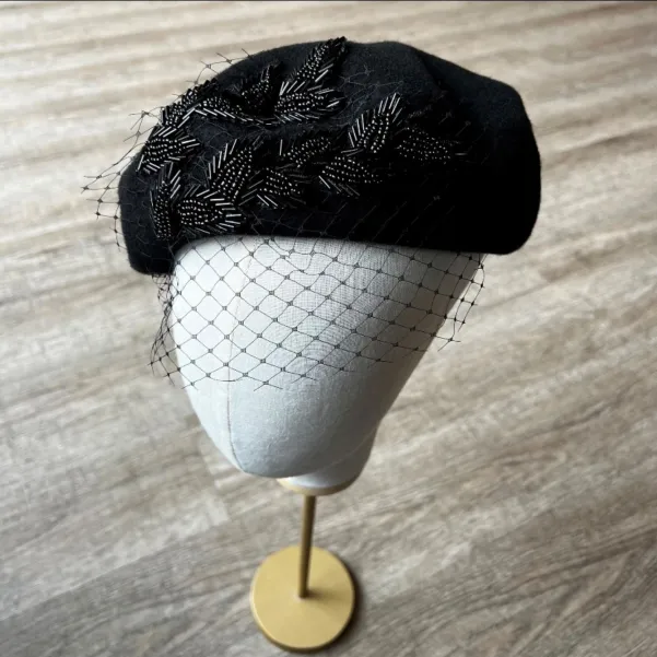 Stylowy beret damski z koralikami i woalką.