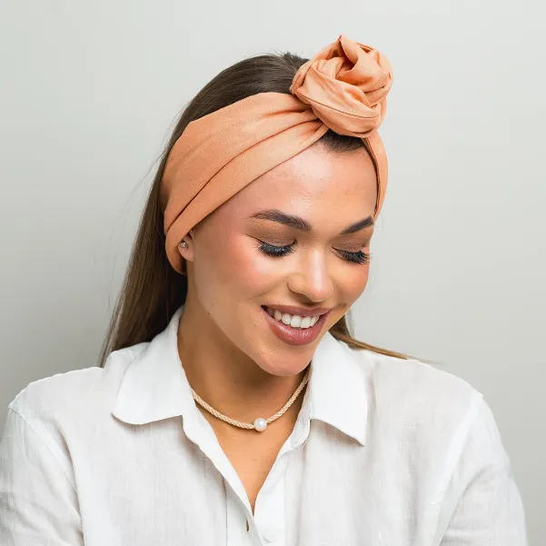 Lniana opaska twistband w kolorze brzoskwiniowym.