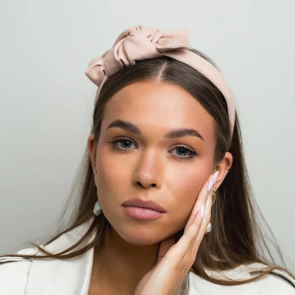 Lniana na pudrowa opaska damska z ozdobną kokardą.