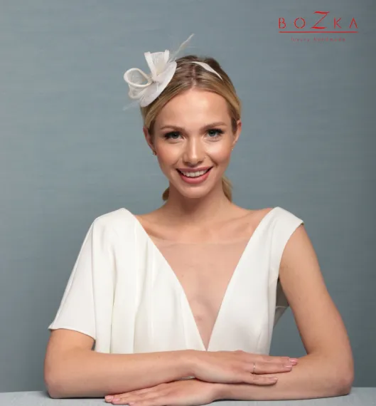 Gustowny ślubny stroik z delikatnymi piórkami.