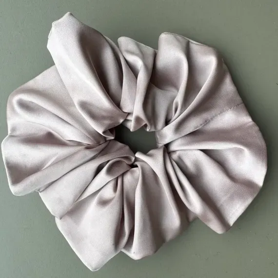Duża, jedwabista gumka scrunchie w odcieniu pudrowy róż.