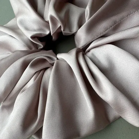 Duża, jedwabista gumka scrunchie w odcieniu pudrowy róż.