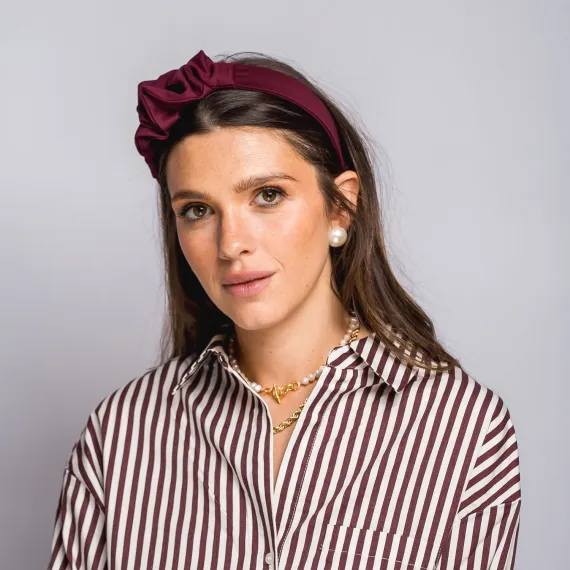 Bordowa opaska do włosów z niewielką ozdobą.