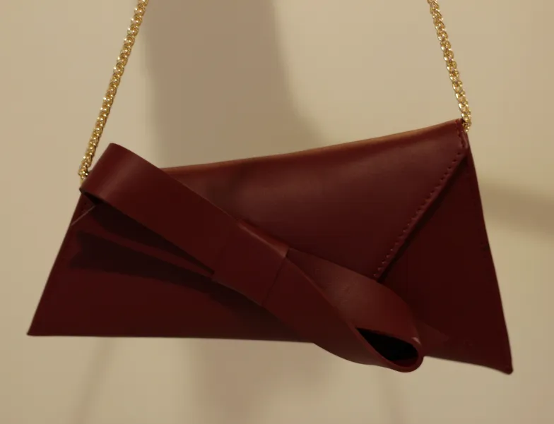 Bordowa torebka wizytowa na łańcuszku.