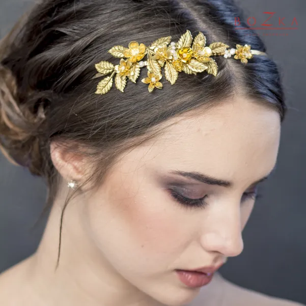 Złota biżuteryjna opaska na głowę z kwiatkami.